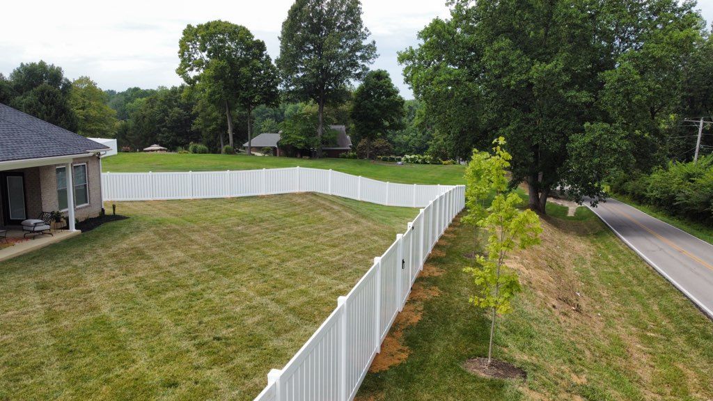 An aerial view of a white fence surrounding a house.