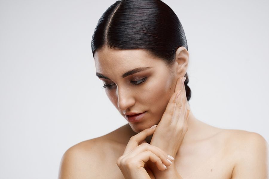 A Woman Touching Her Face — Organic Beauty by Kessie in Yeppoon, QLD