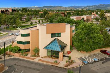 An aerial view of a large building with a parking lot in front of it.