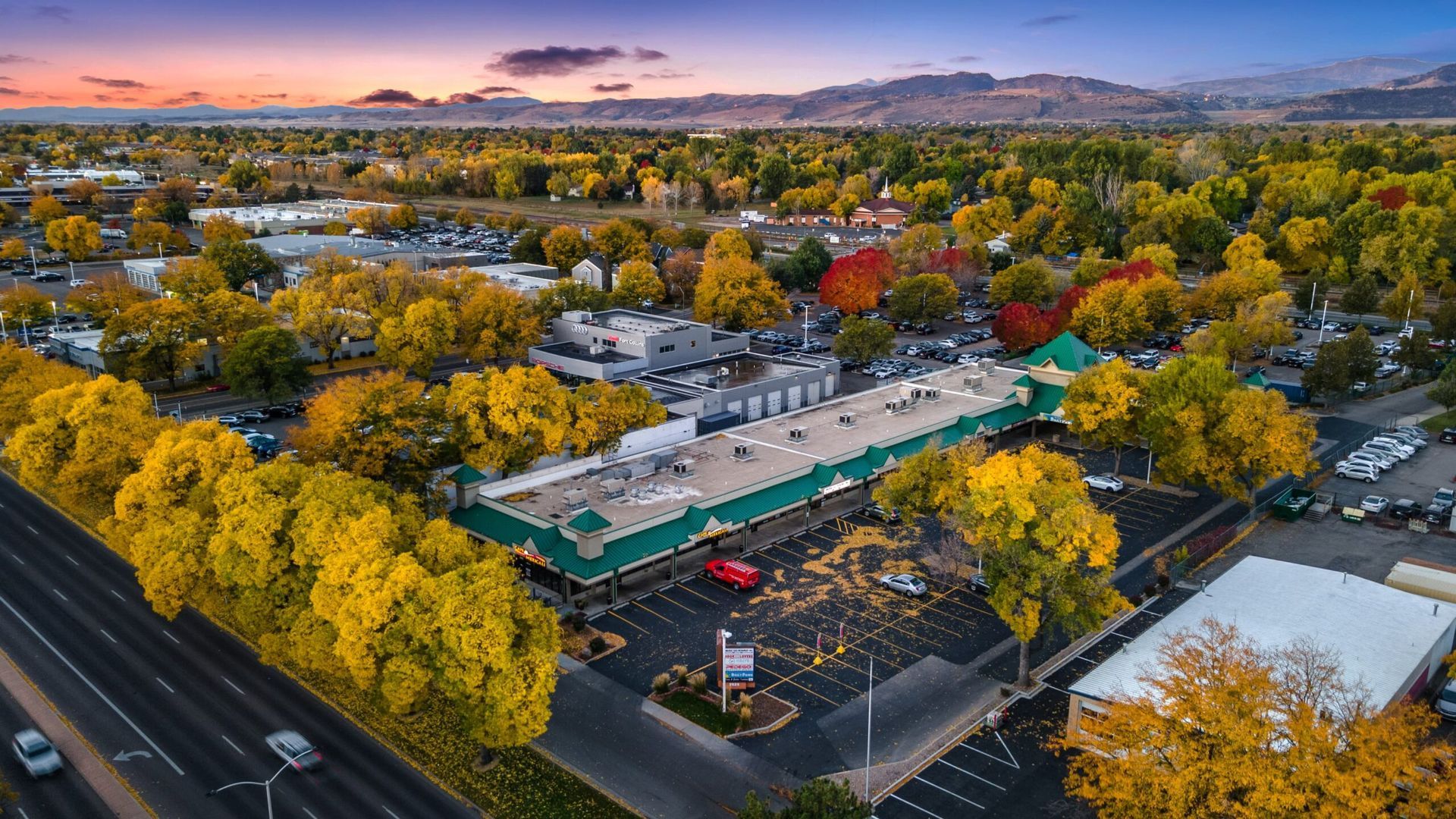 An aerial view of a large building surrounded by trees and a parking lot.
