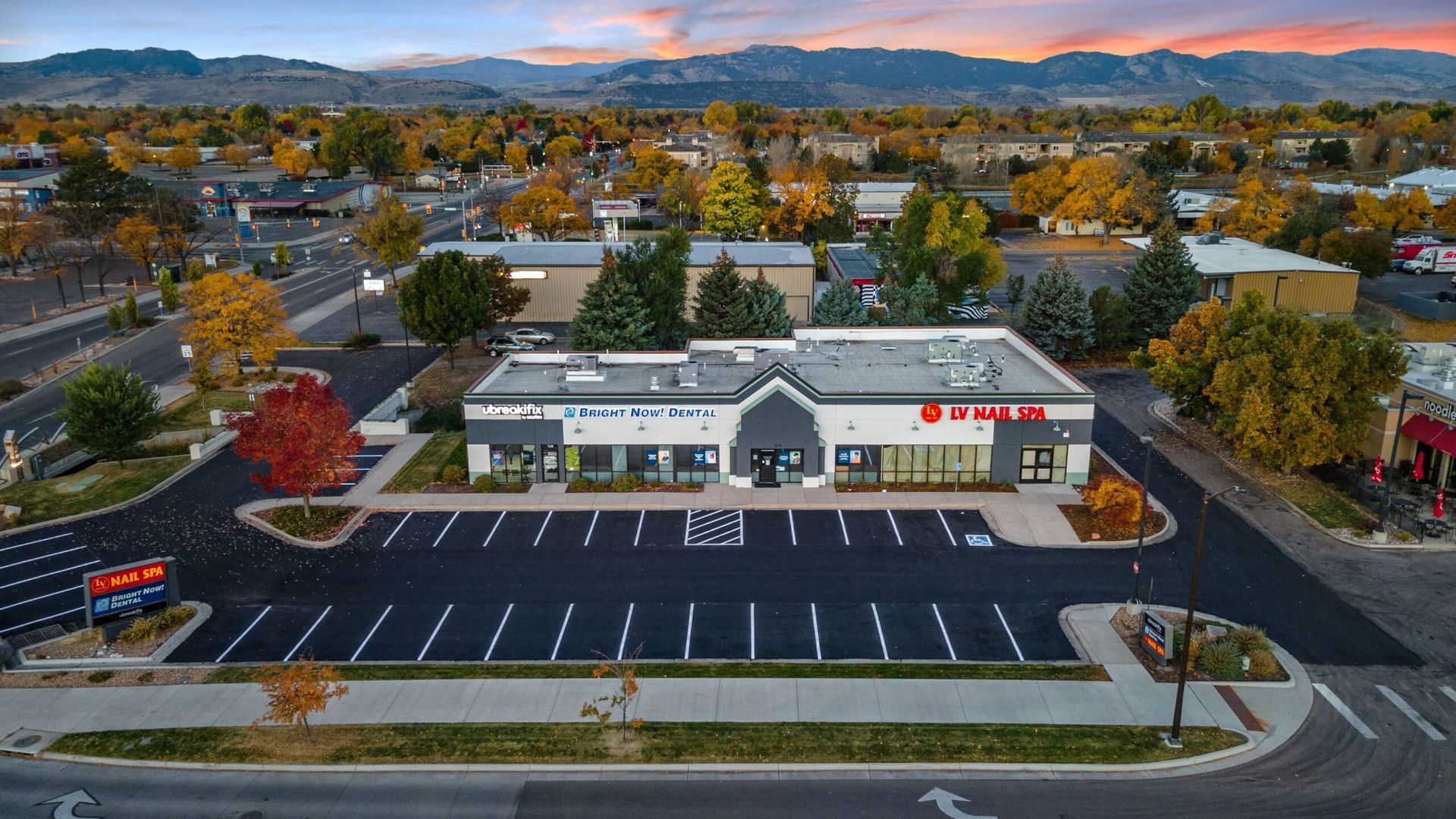 An aerial view of a building with a parking lot in front of it.