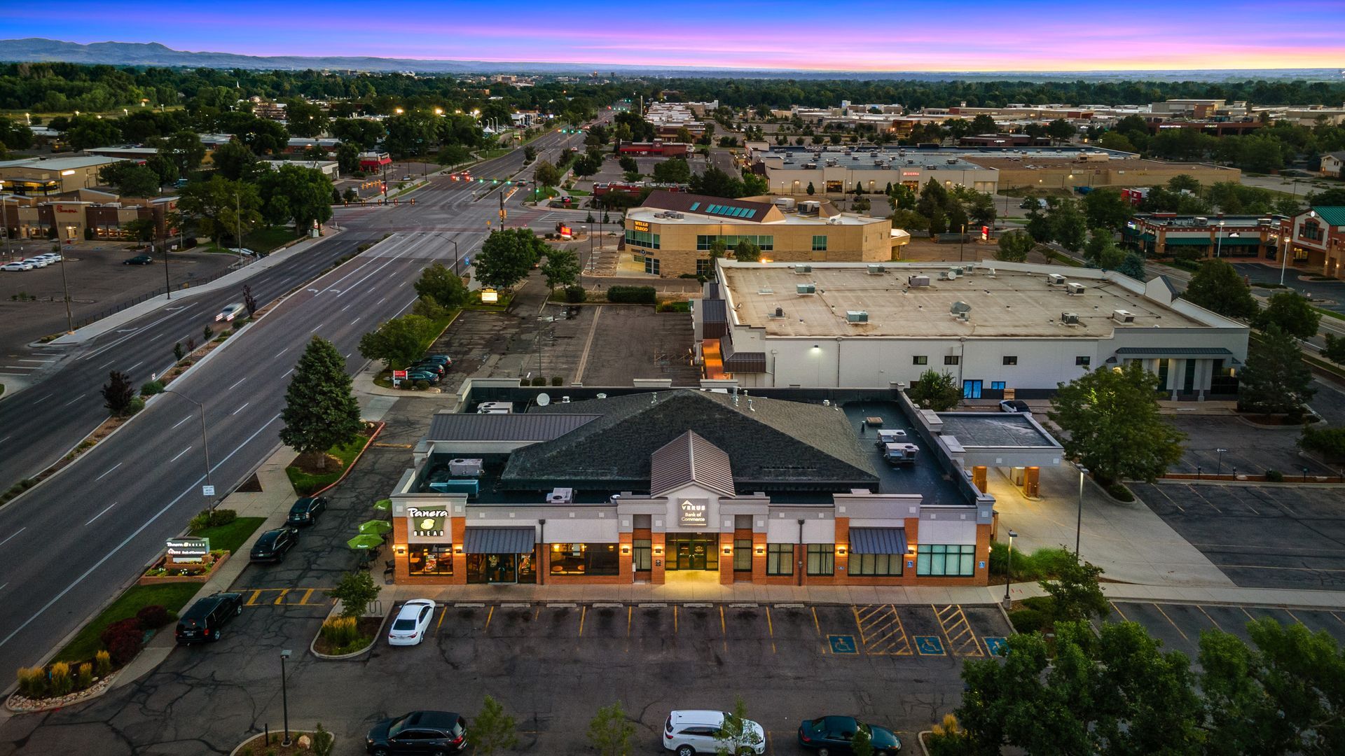 An aerial view of a large building with a parking lot in front of it.