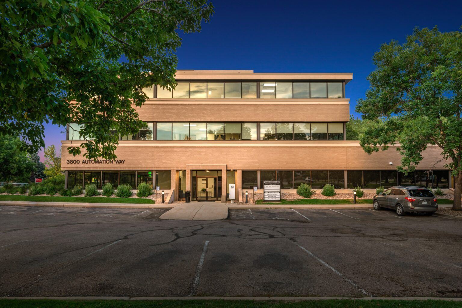 A large brick building with a car parked in front of it.