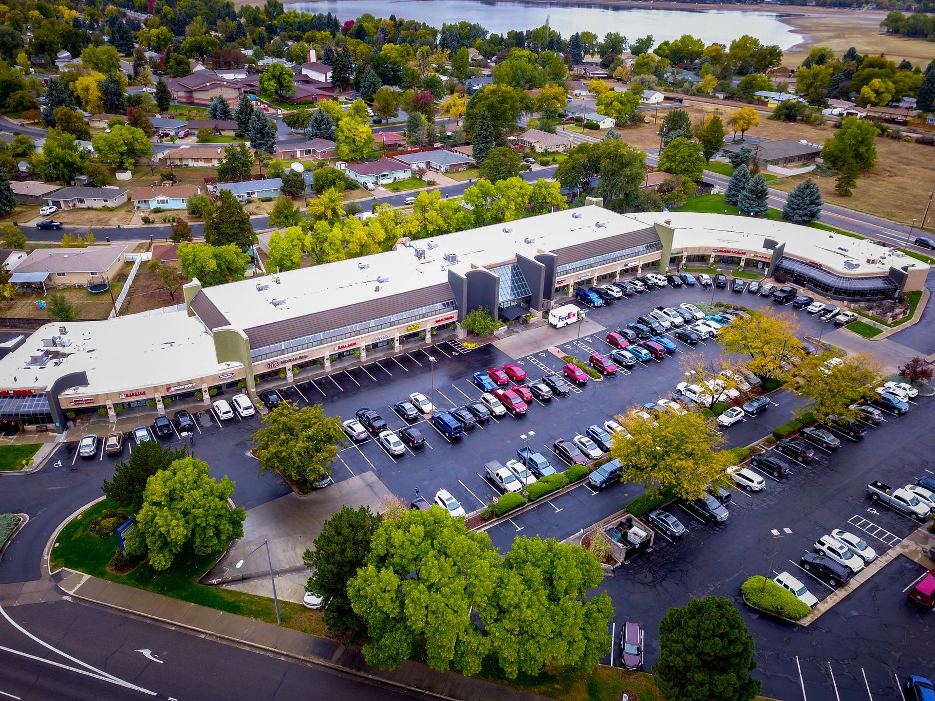 An aerial view of a parking lot with a large building in the background.