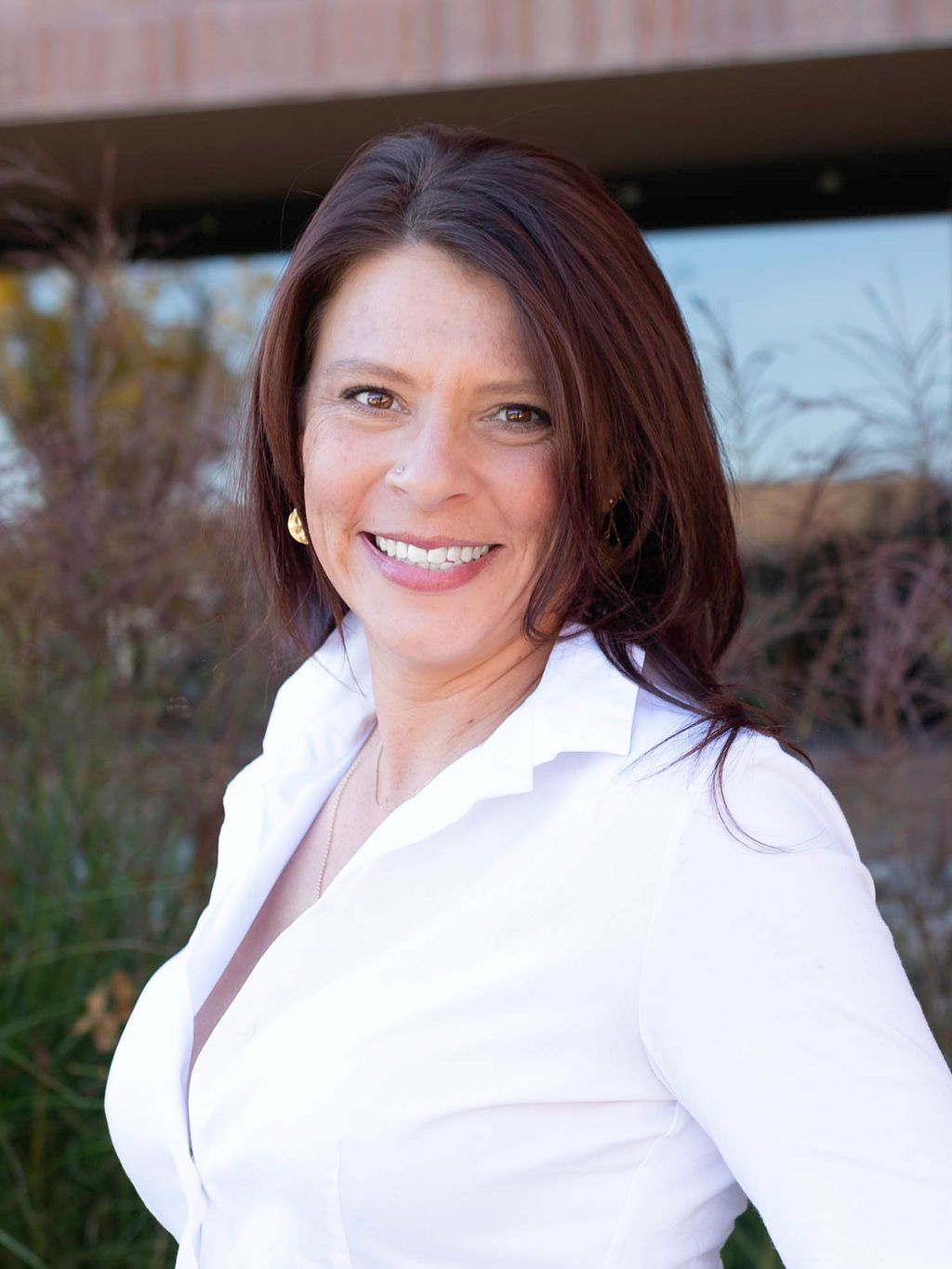 A woman in a green dress is smiling for the camera.