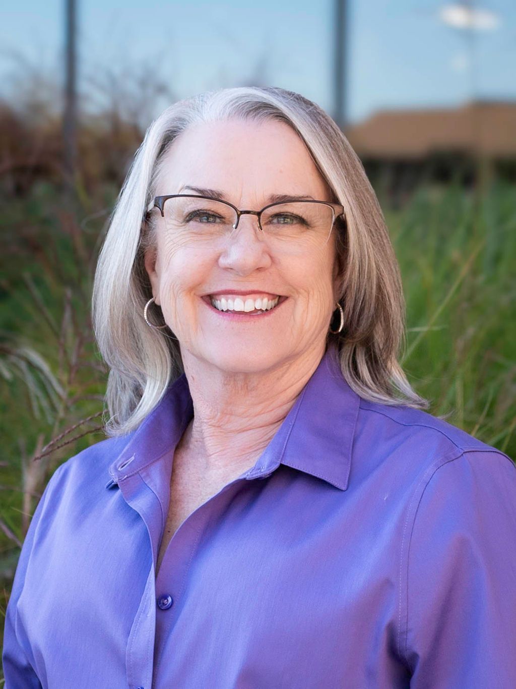 A woman in a green dress is smiling for the camera.