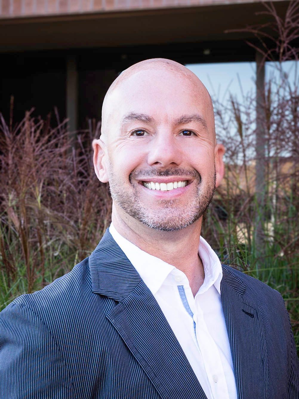 A man in a suit and tie is smiling for the camera.