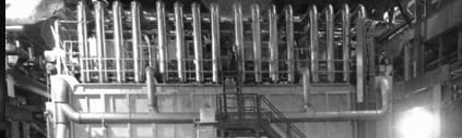 Ein Schwarzweißfoto einer Fabrik mit Rohren und Treppen.