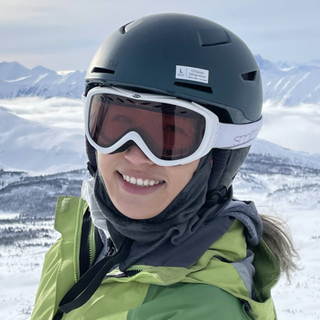 Ashley, an EVR employee, wearing a helmet sitting on an off road bike in the Rocky Mountains.