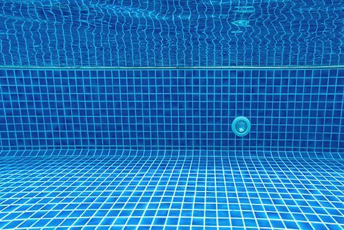 A swimming pool with blue tiles and blue water. A swimming pool with blue tiles and blue water.