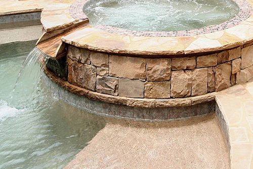 A hot tub with a waterfall in the middle of it.