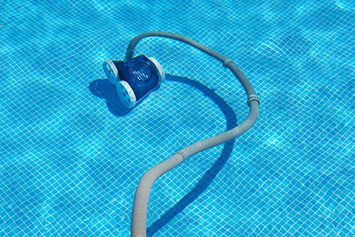 A robotic vacuum cleaner is floating on top of a swimming pool.