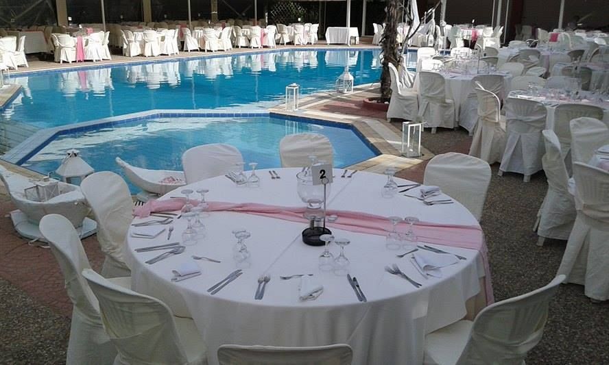 Tables and chairs are set up in front of a swimming pool