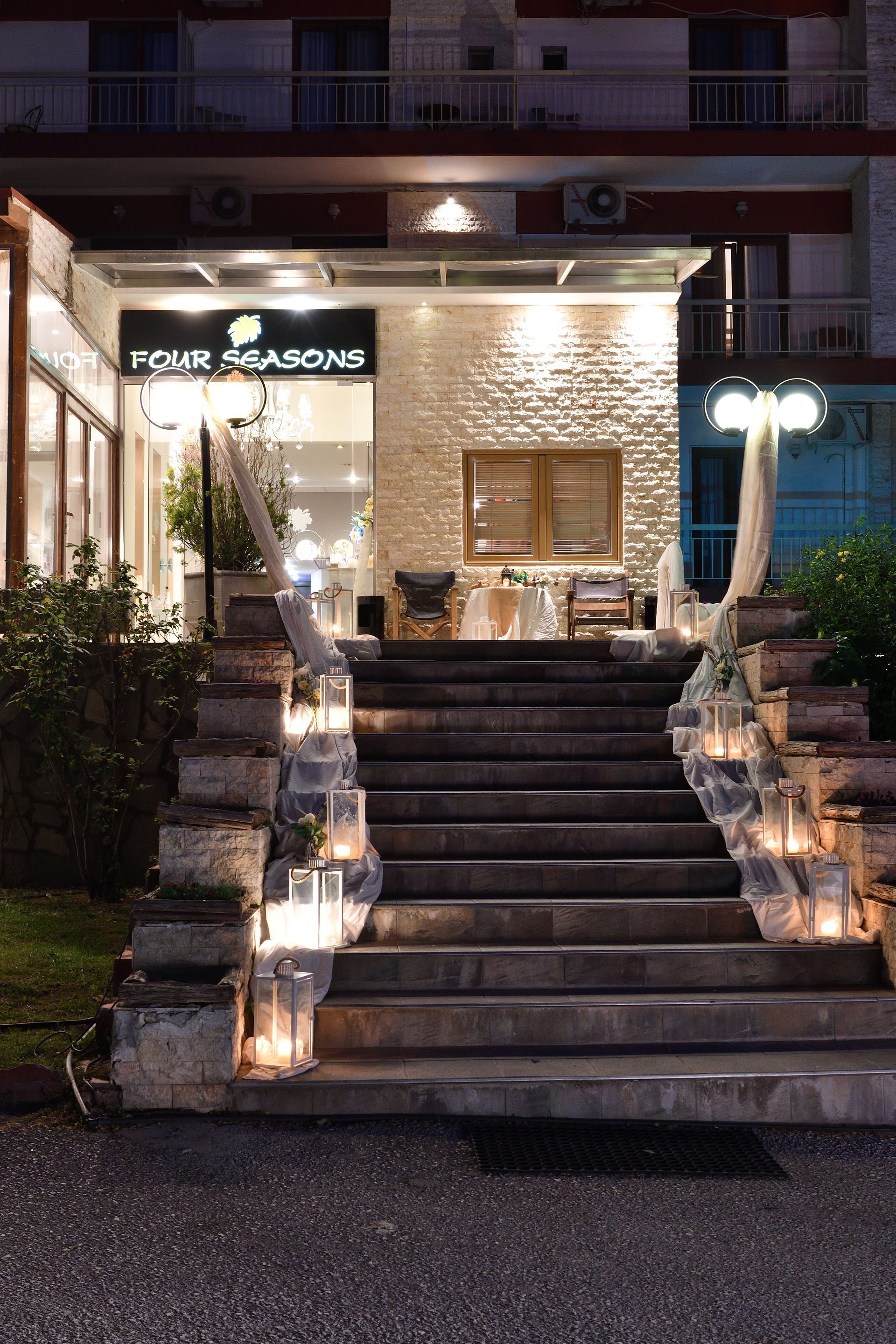 A set of stairs leading up to a building decorated with candles and lanterns.