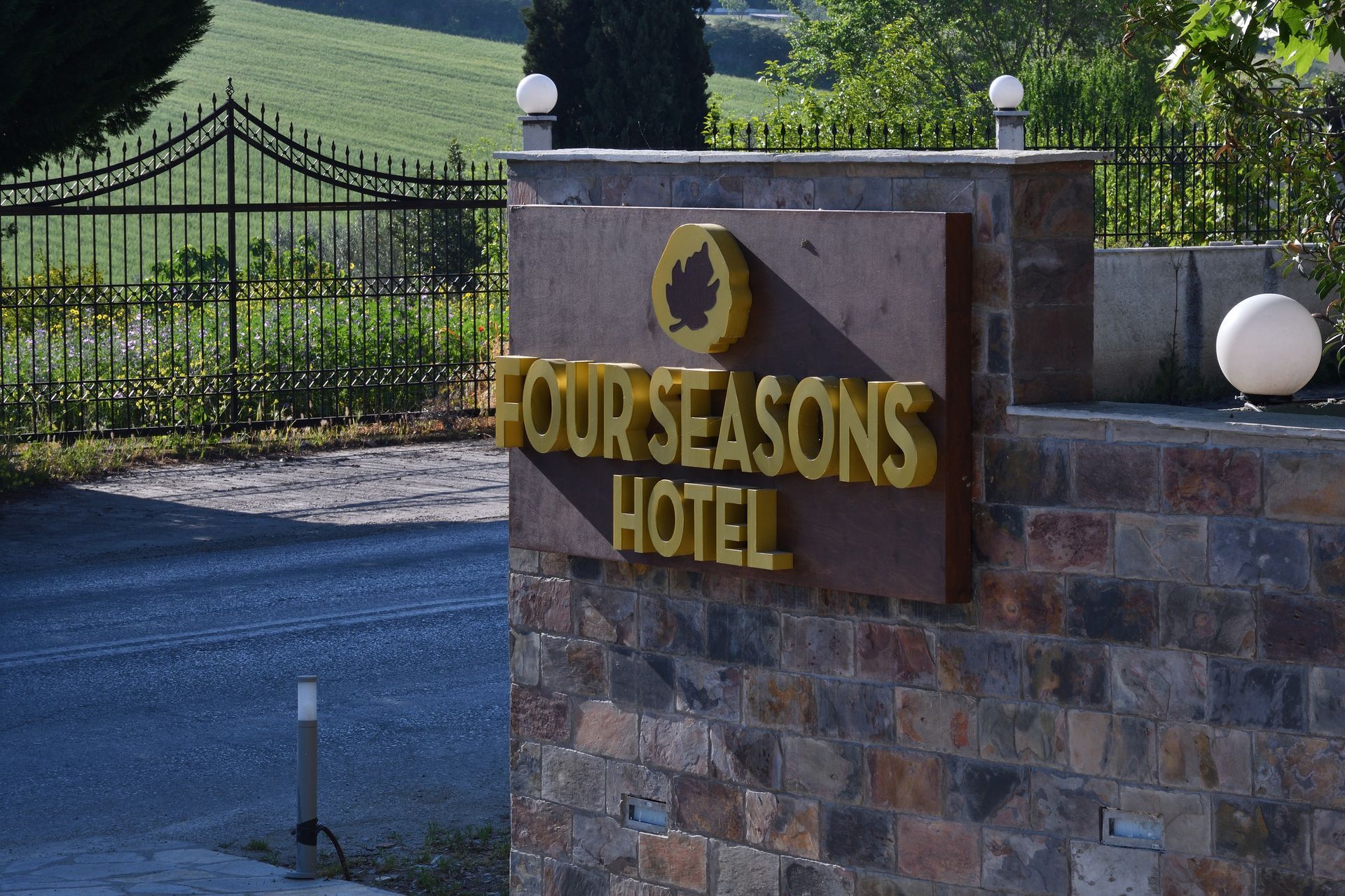 A sign for the four seasons hotel is on a stone wall