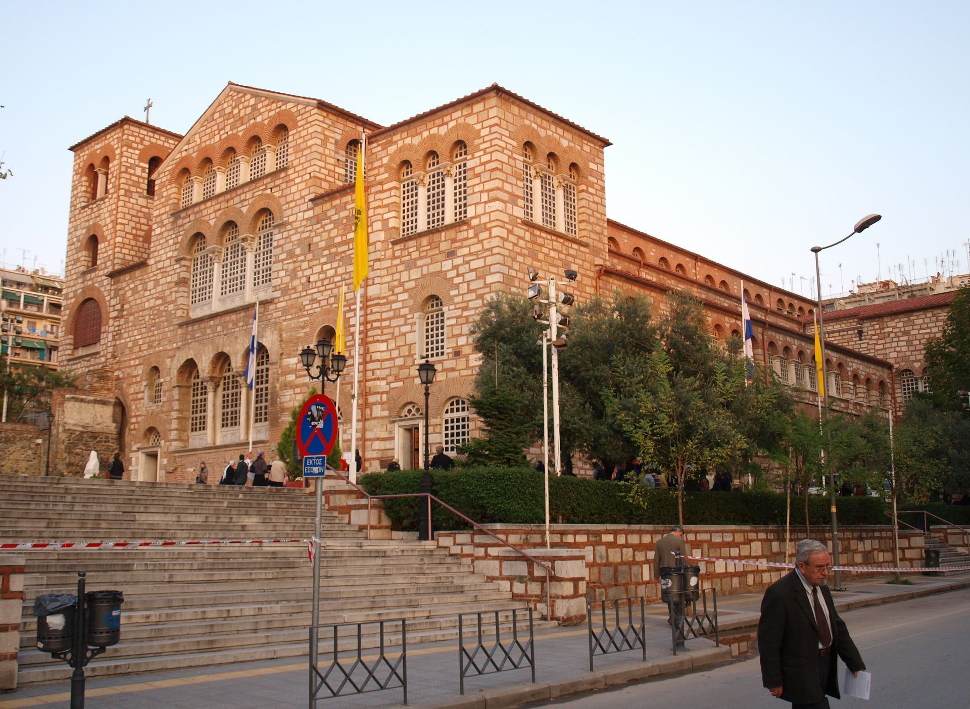 A man walking down a street in front of a large building