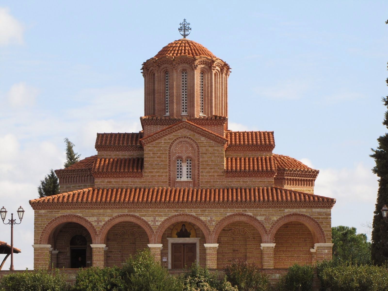 A church with a red tiled roof and a cross on top
