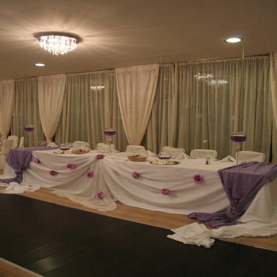 A long white table with purple flowers on it