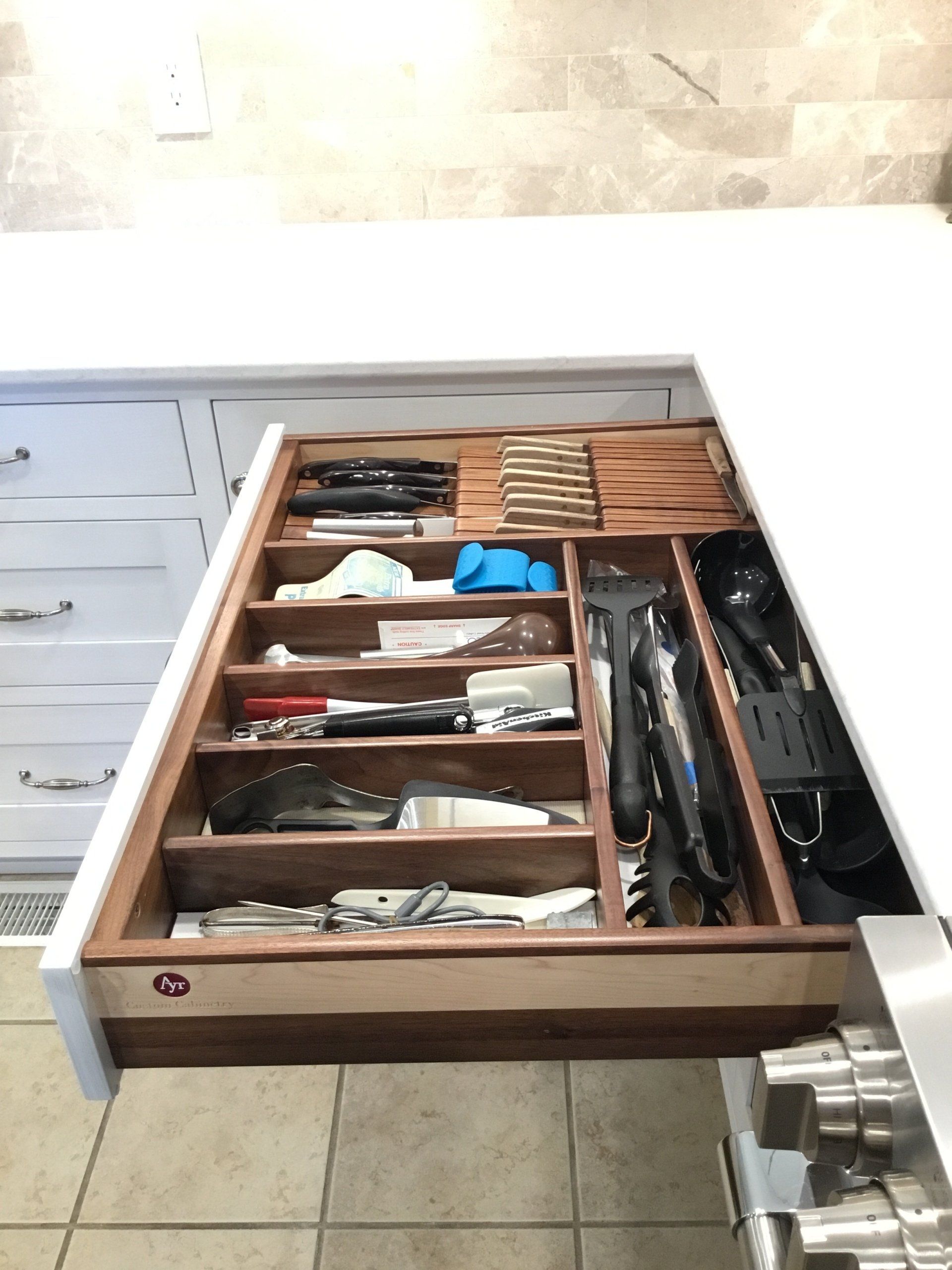 A kitchen drawer filled with utensils and knives