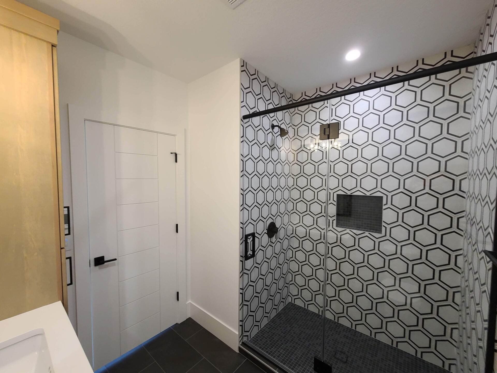A bathroom with a walk in shower and a sink
