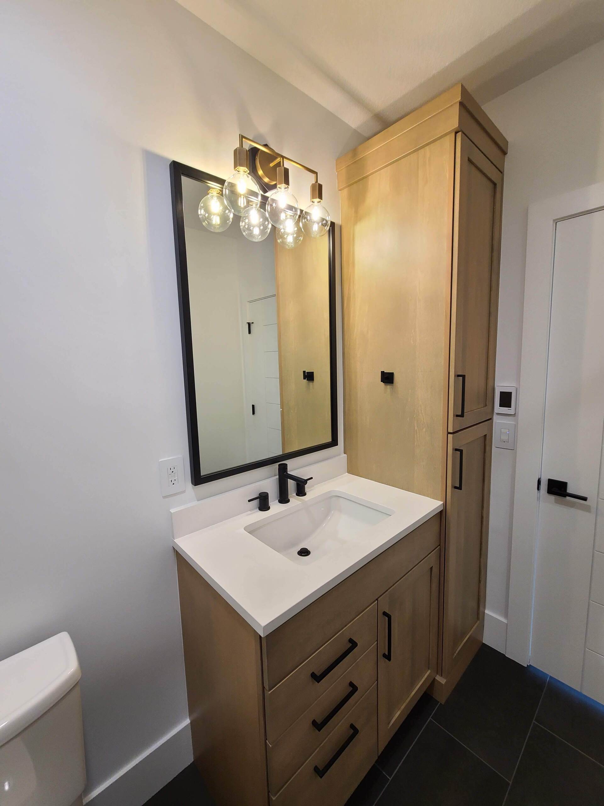 A bathroom with a sink , mirror and toilet