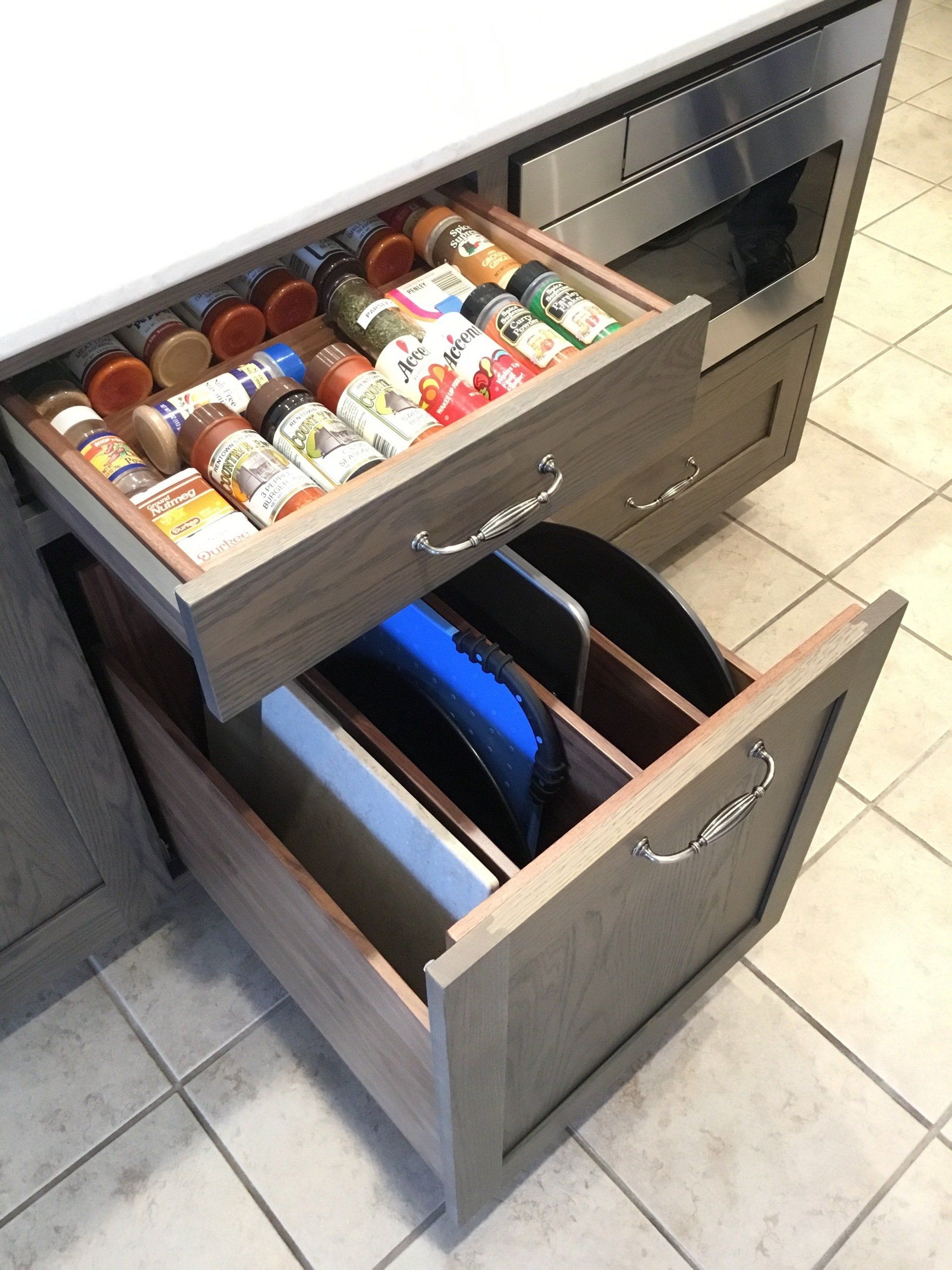 A kitchen drawer filled with spices and cutting boards
