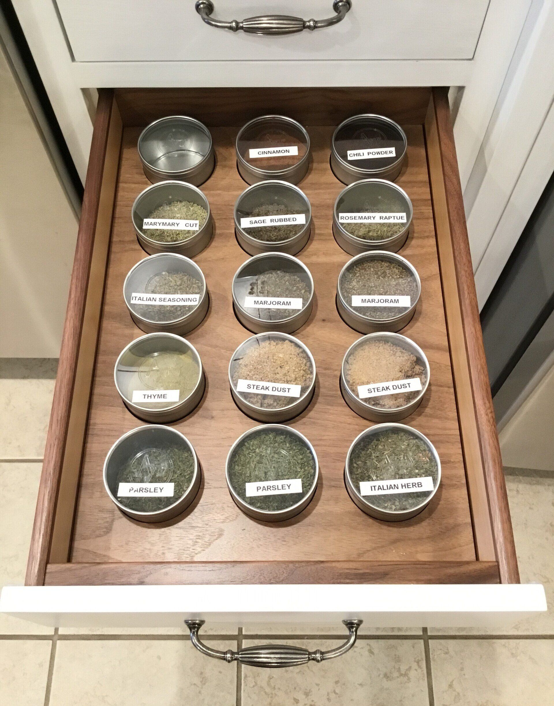 A wooden drawer filled with a variety of spices.