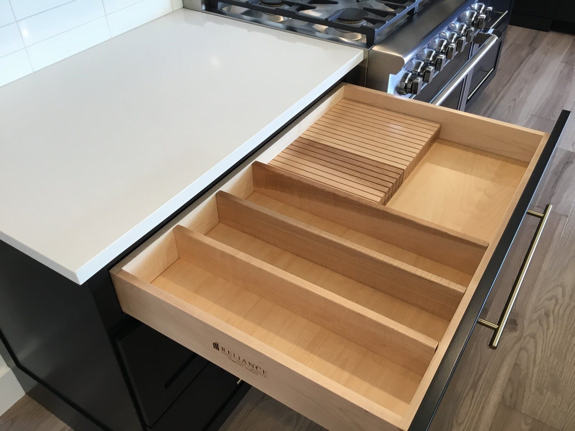 A wooden drawer in a kitchen next to a stove