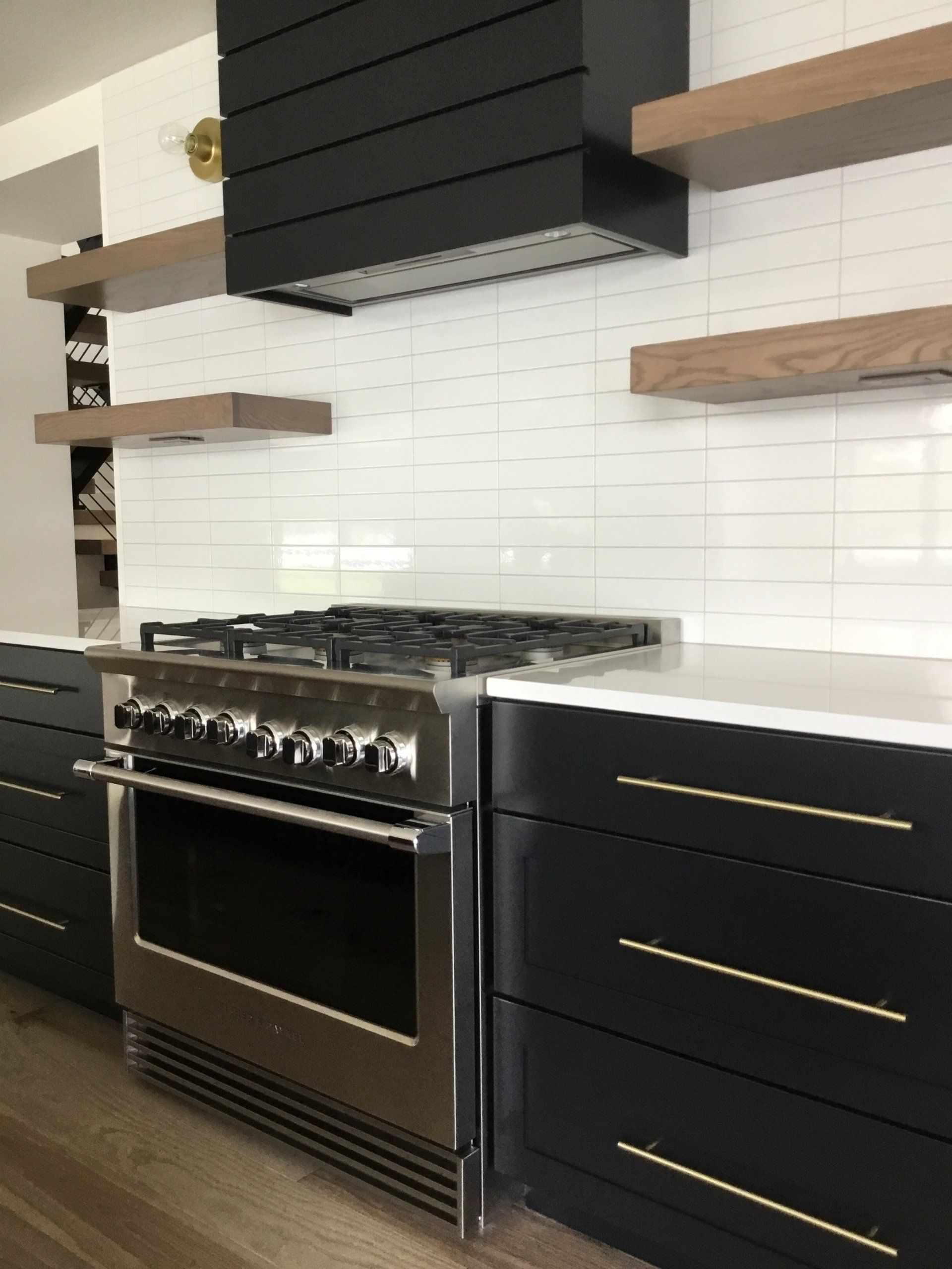 A kitchen with stainless steel appliances and black cabinets