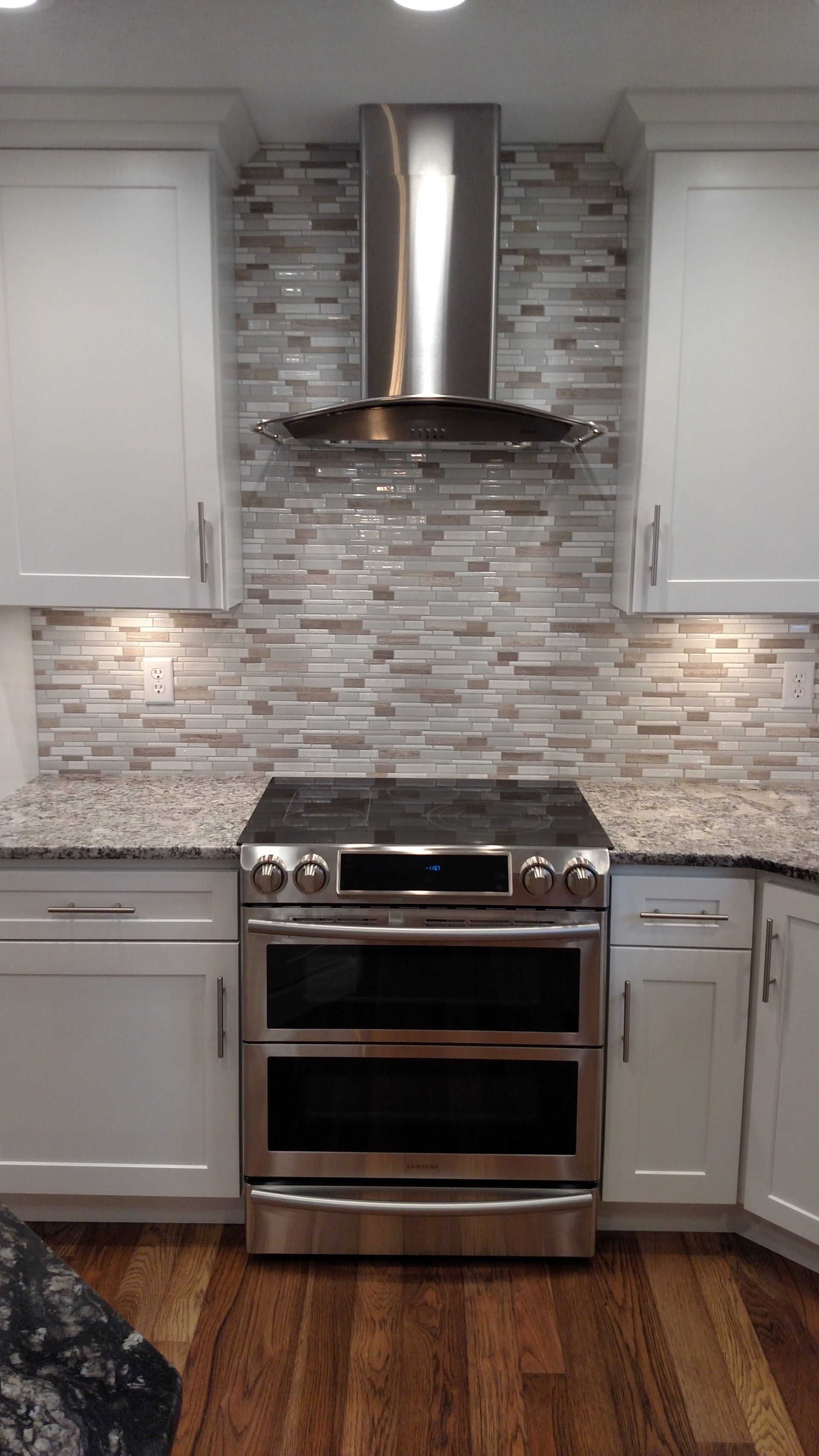 A kitchen with stainless steel appliances and white cabinets.