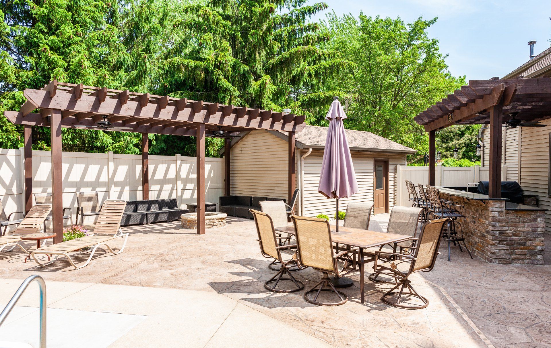 A patio with a table and chairs under a pergola.