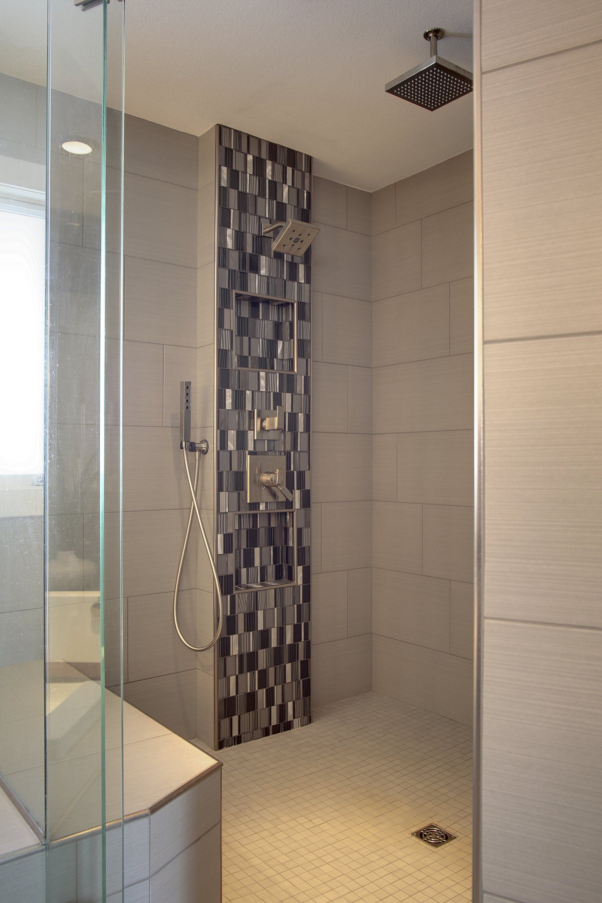 A bathroom with a walk in shower and a shower head.