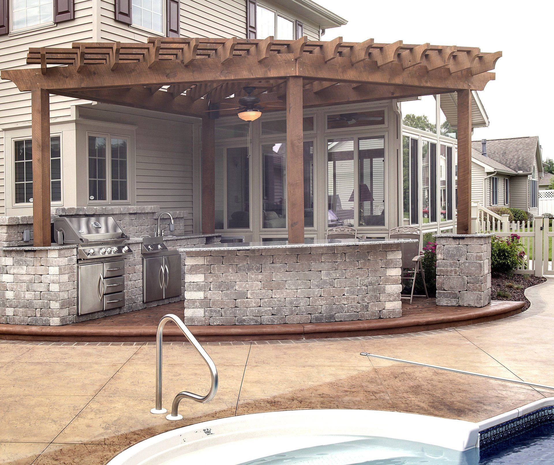 A house with a pergola and a hot tub in front of it