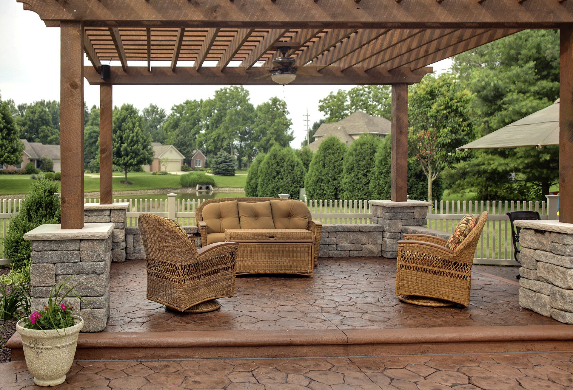 A patio with a couch and chairs under a pergola