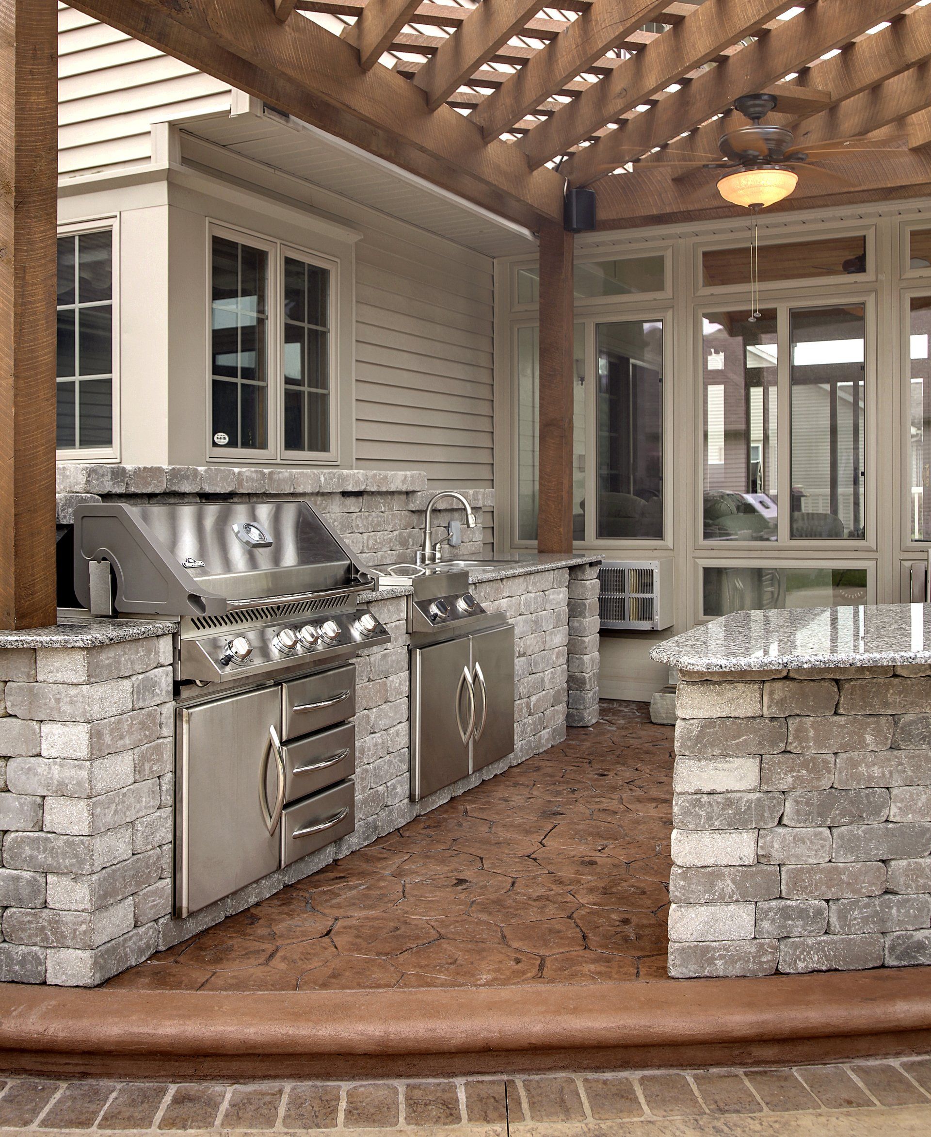 An outdoor kitchen with stainless steel appliances and granite counter tops