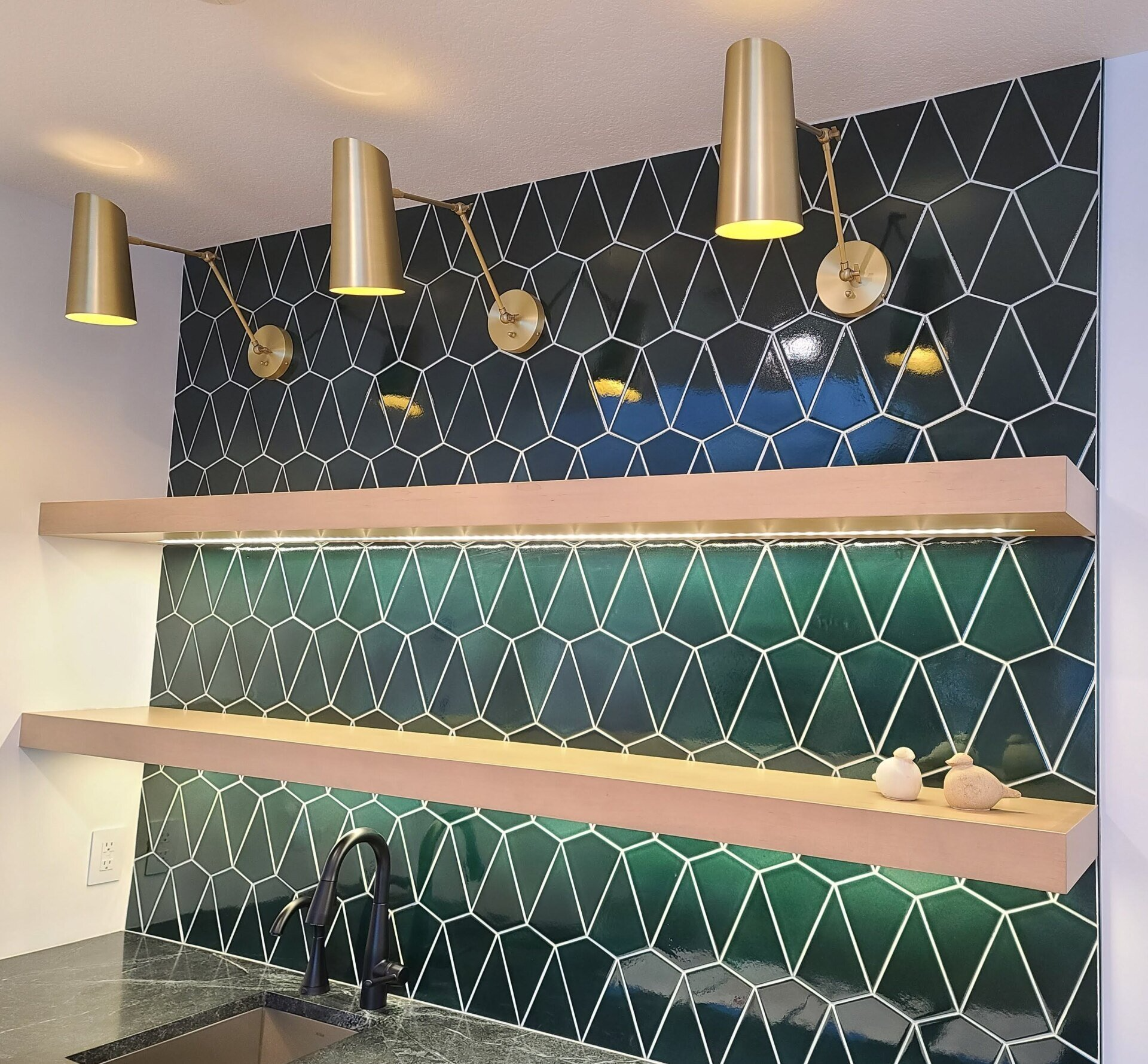 A kitchen with green tiles and a sink