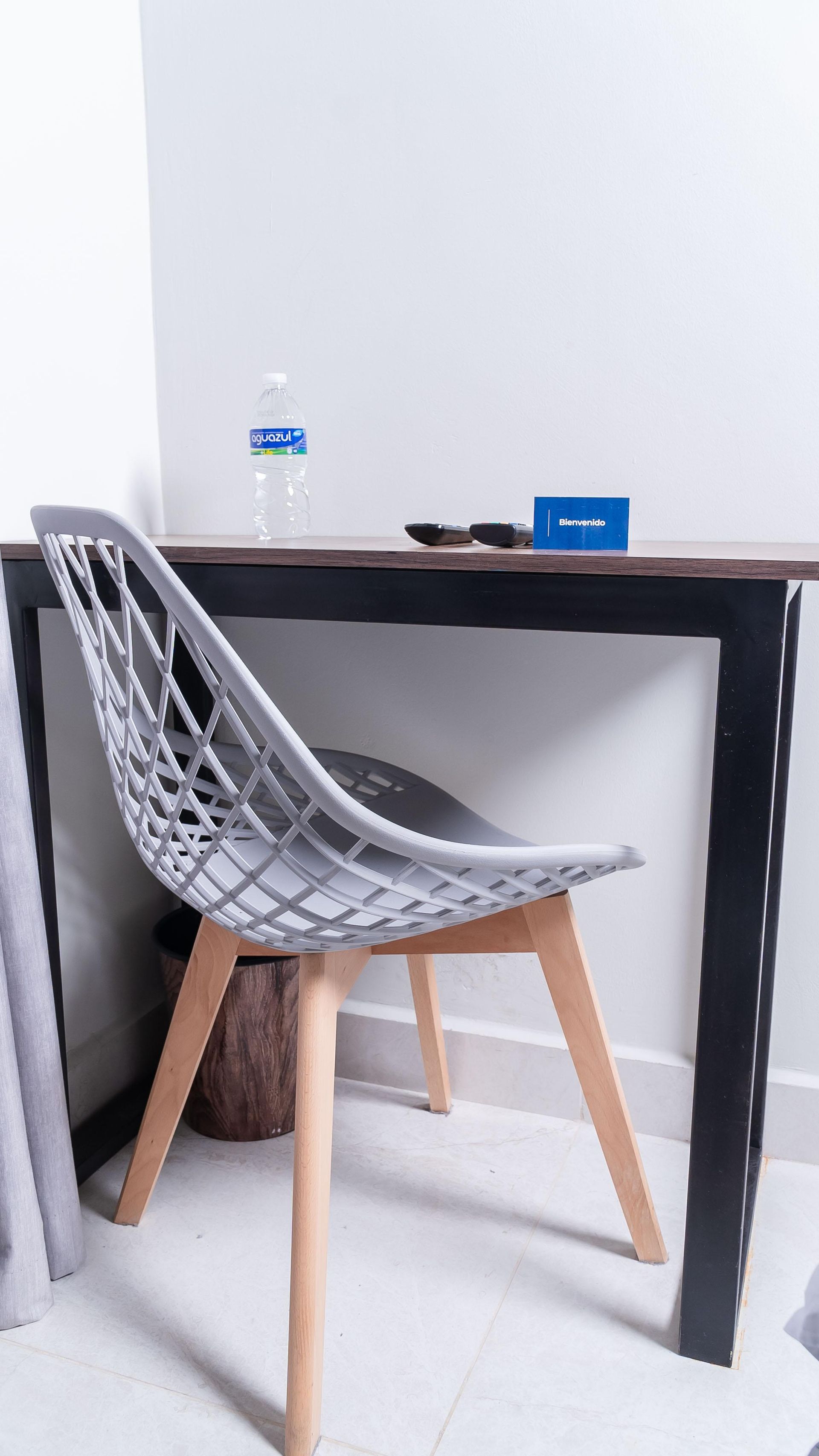 Un escritorio de madera con una silla y una lámpara en una habitación.