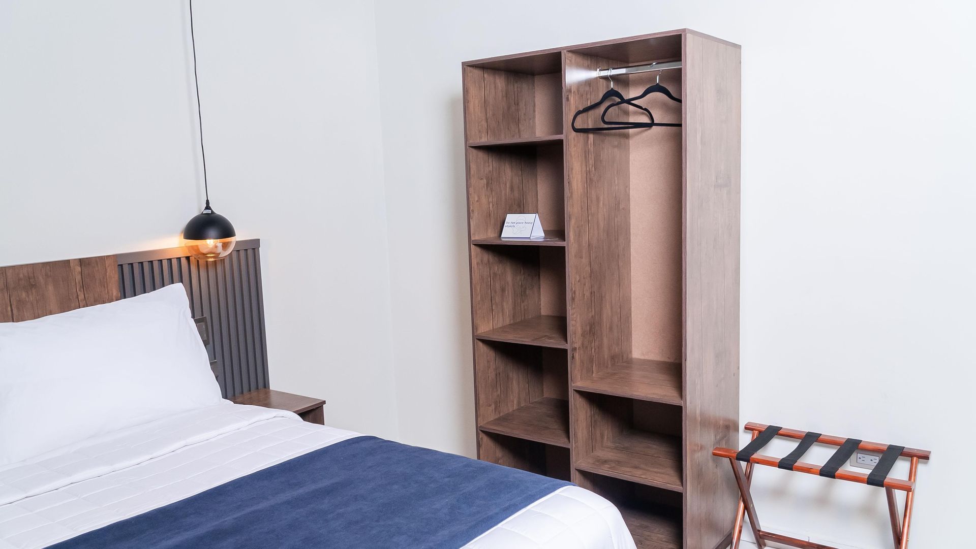 Una planta en maceta está sentada sobre un taburete de madera en una habitación al lado de una cómoda.