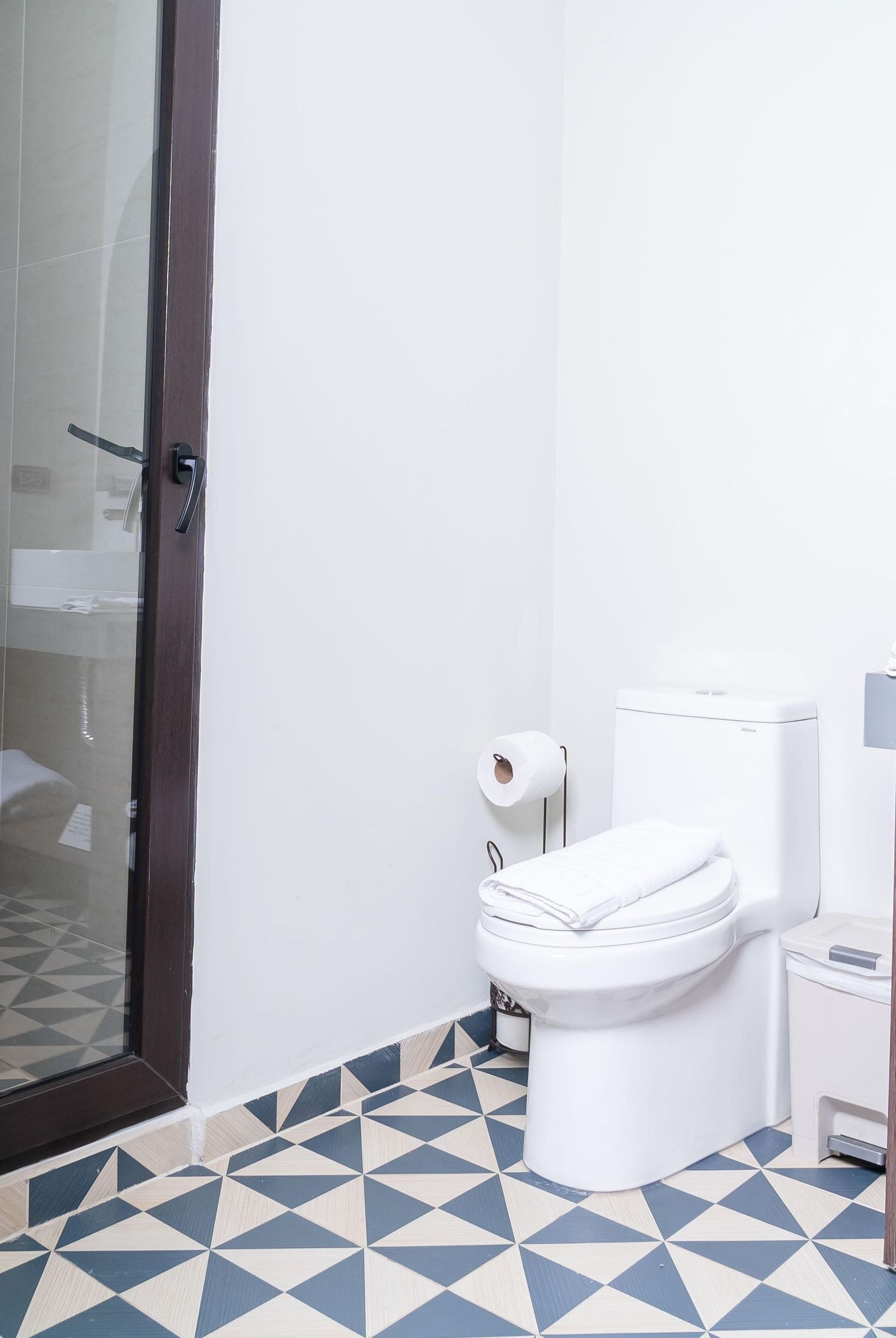 Un dormitorio con cama, silla, alfombra y plantas.