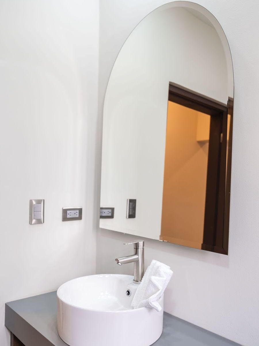 Un baño con inodoro, lavabo y espejo.