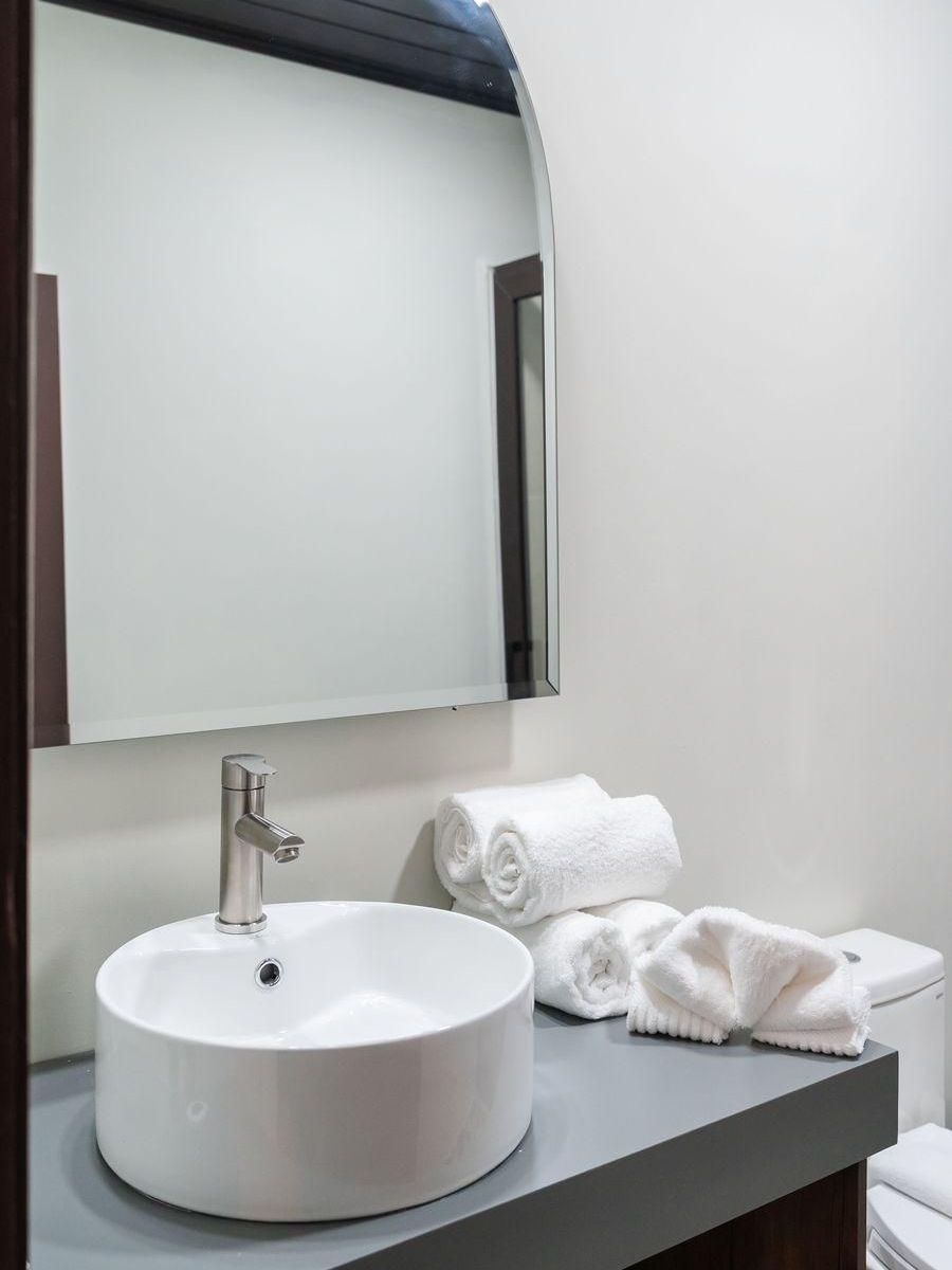 Una planta en maceta está sentada sobre un taburete de madera en una habitación al lado de una cómoda.