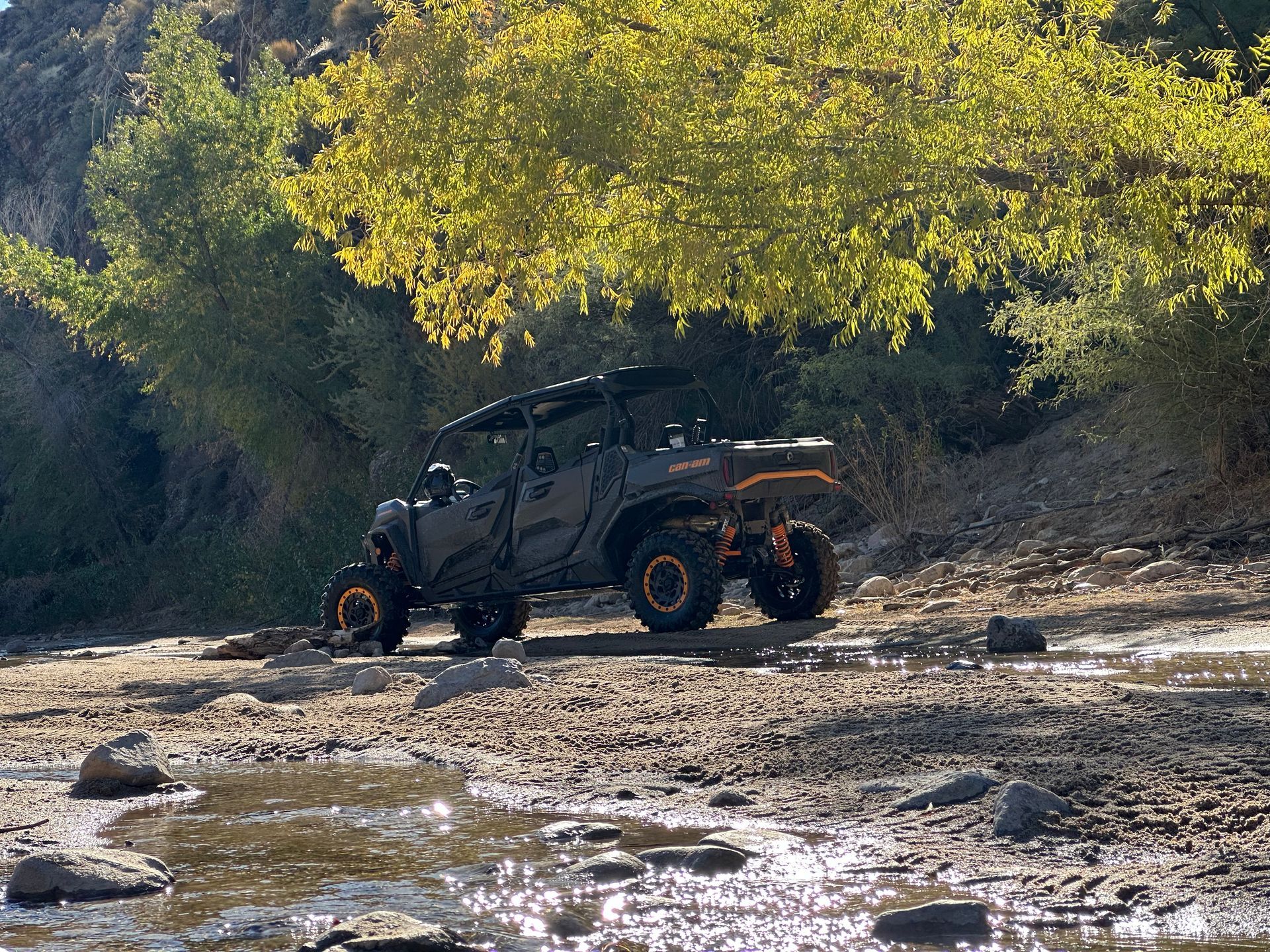 An atv is parked on the side of a river.