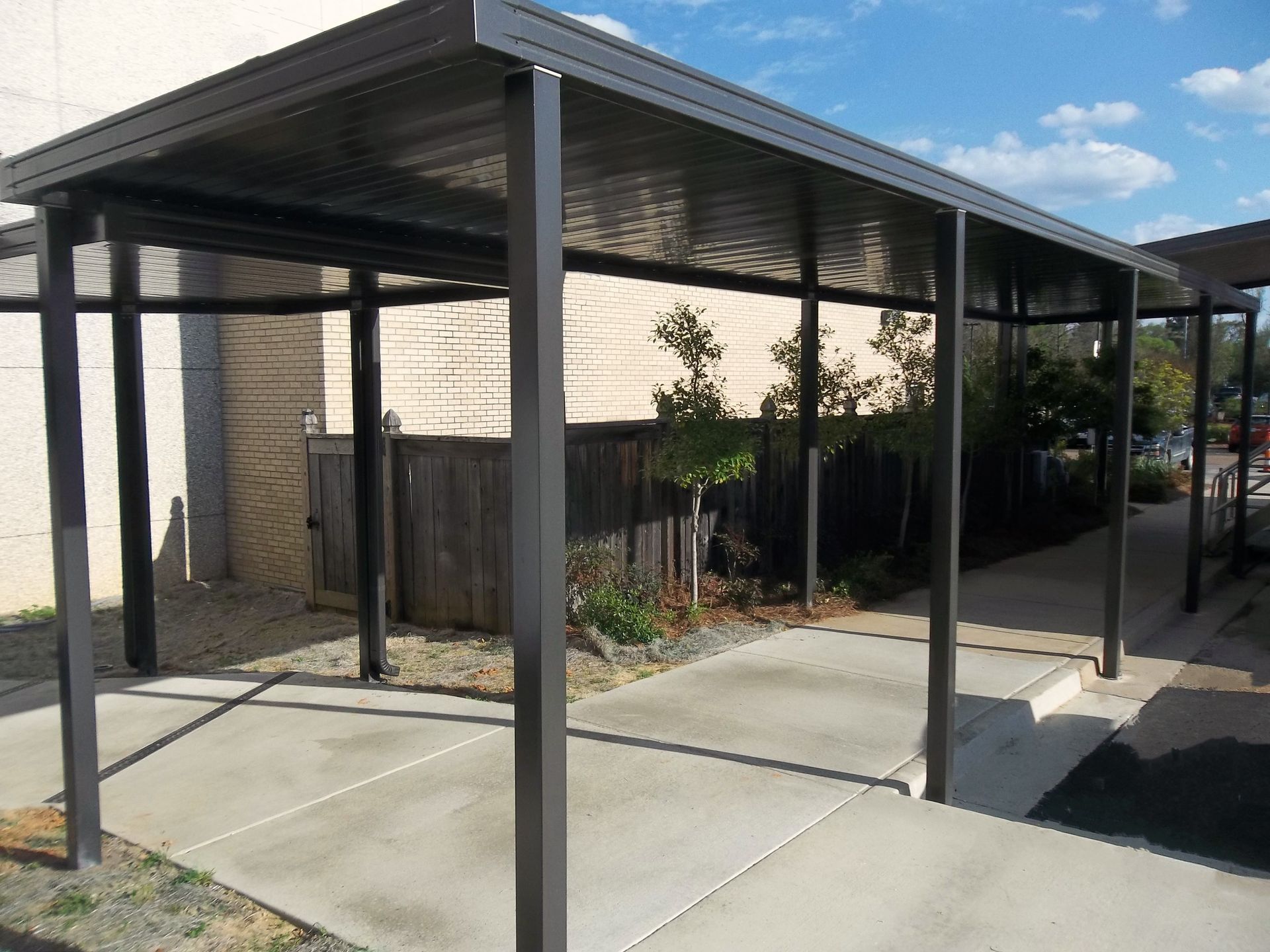a covered walkway with a fence in the background - Road Jackson, MS - French Awning & Screen Co.