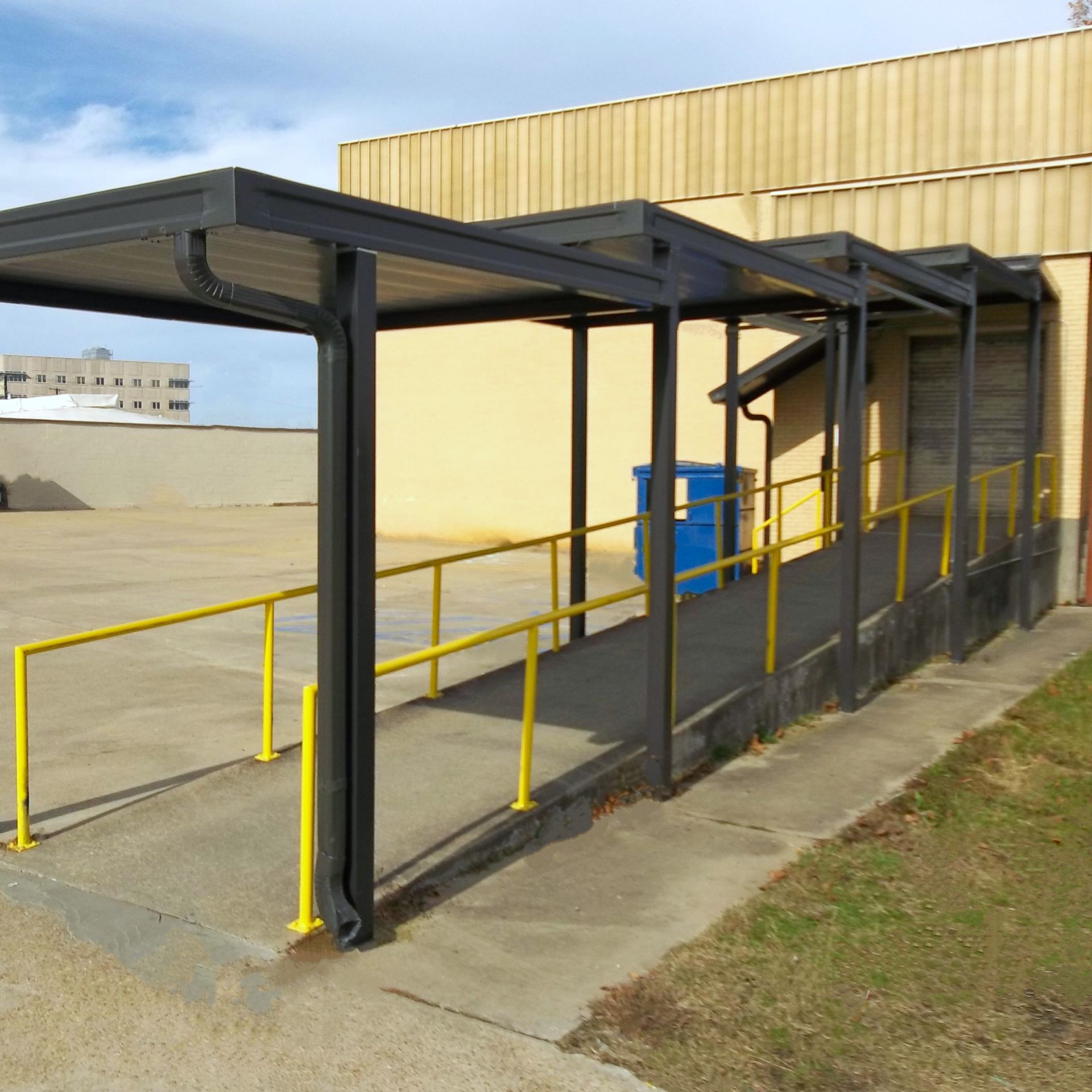 a blue trash can sits under a covered walkway - Road Jackson, MS - French Awning & Screen Co.