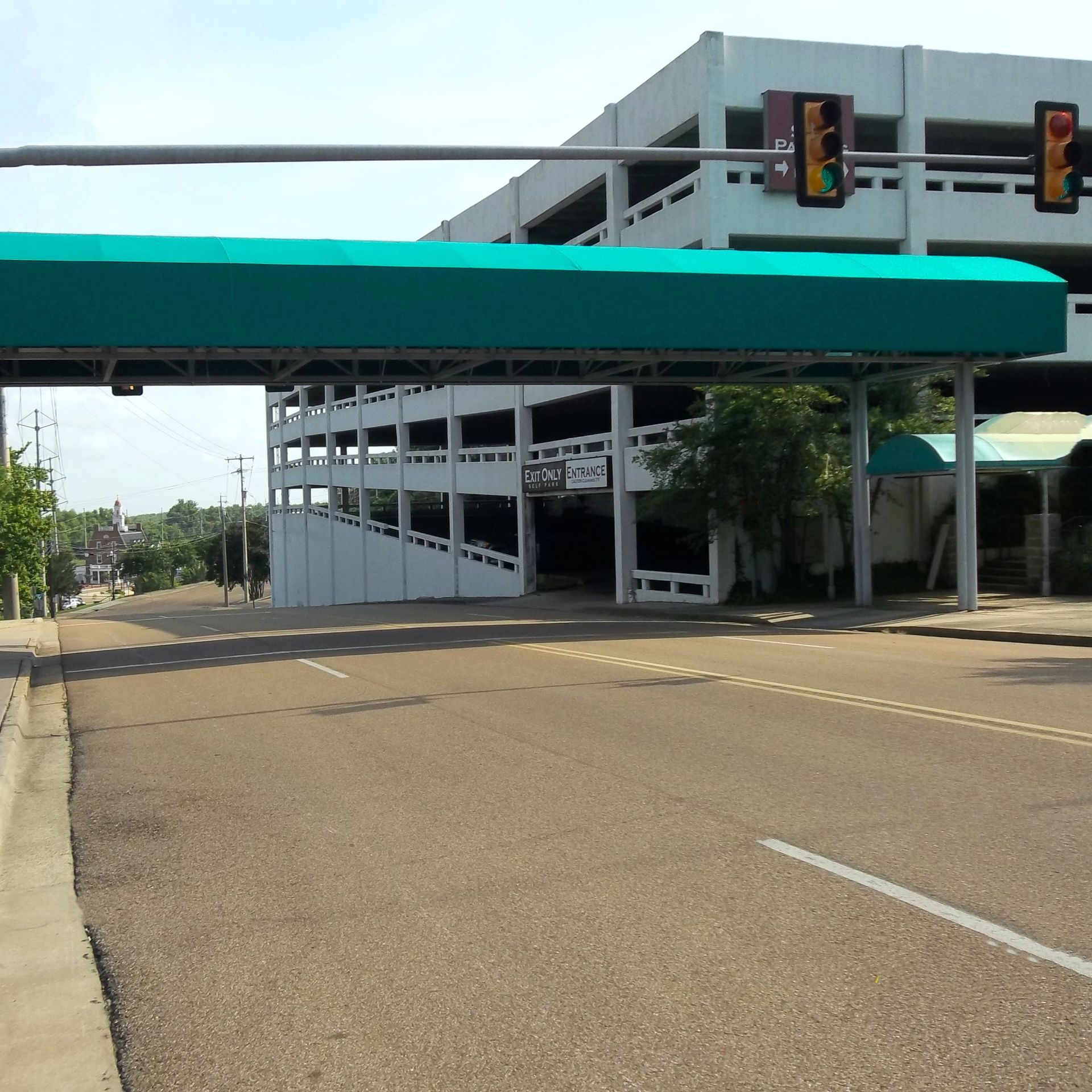 a green awning over a street with a parking garage in the background - Road Jackson, MS - French Awning & Screen Co.
