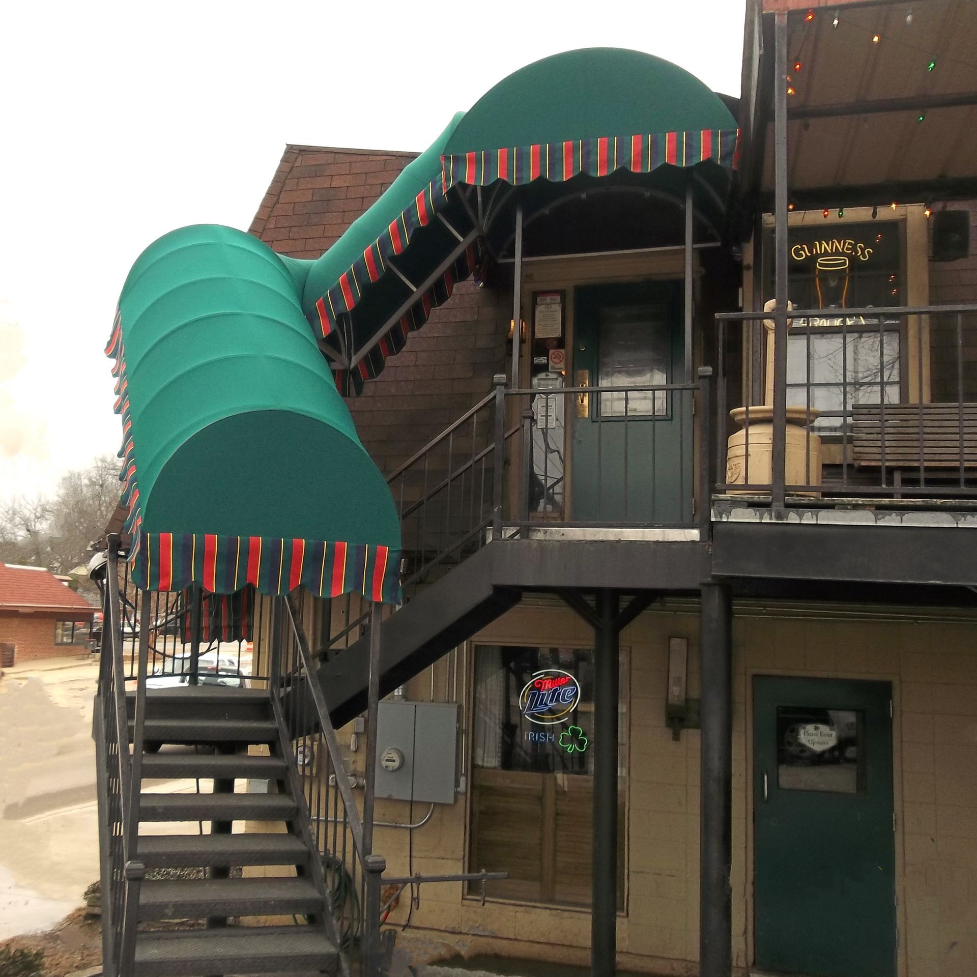 a building with a green awning and stairs leading up to it - Road Jackson, MS - French Awning & Screen Co.