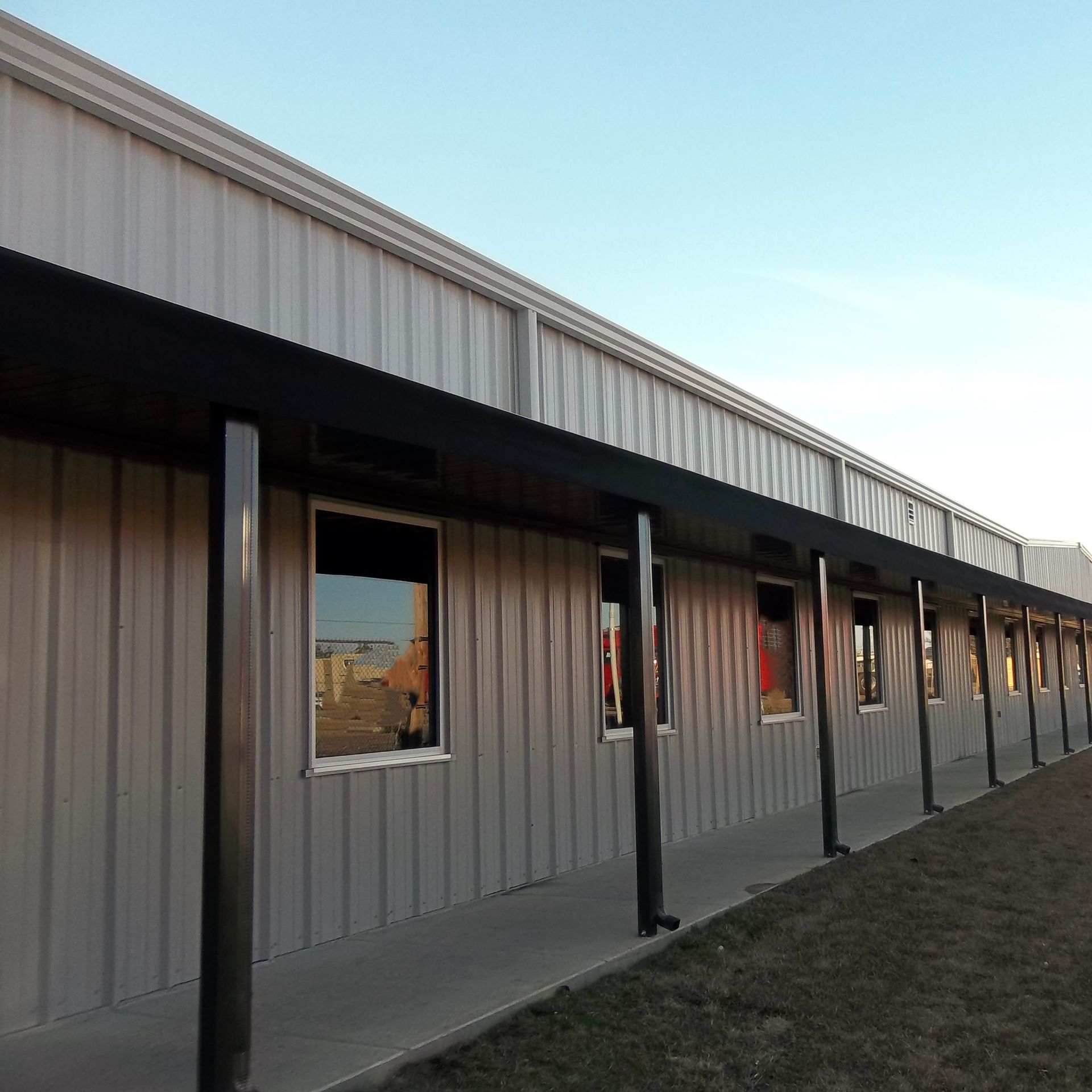a building with a lot of windows and a covered walkway - Road Jackson, MS - French Awning & Screen Co.