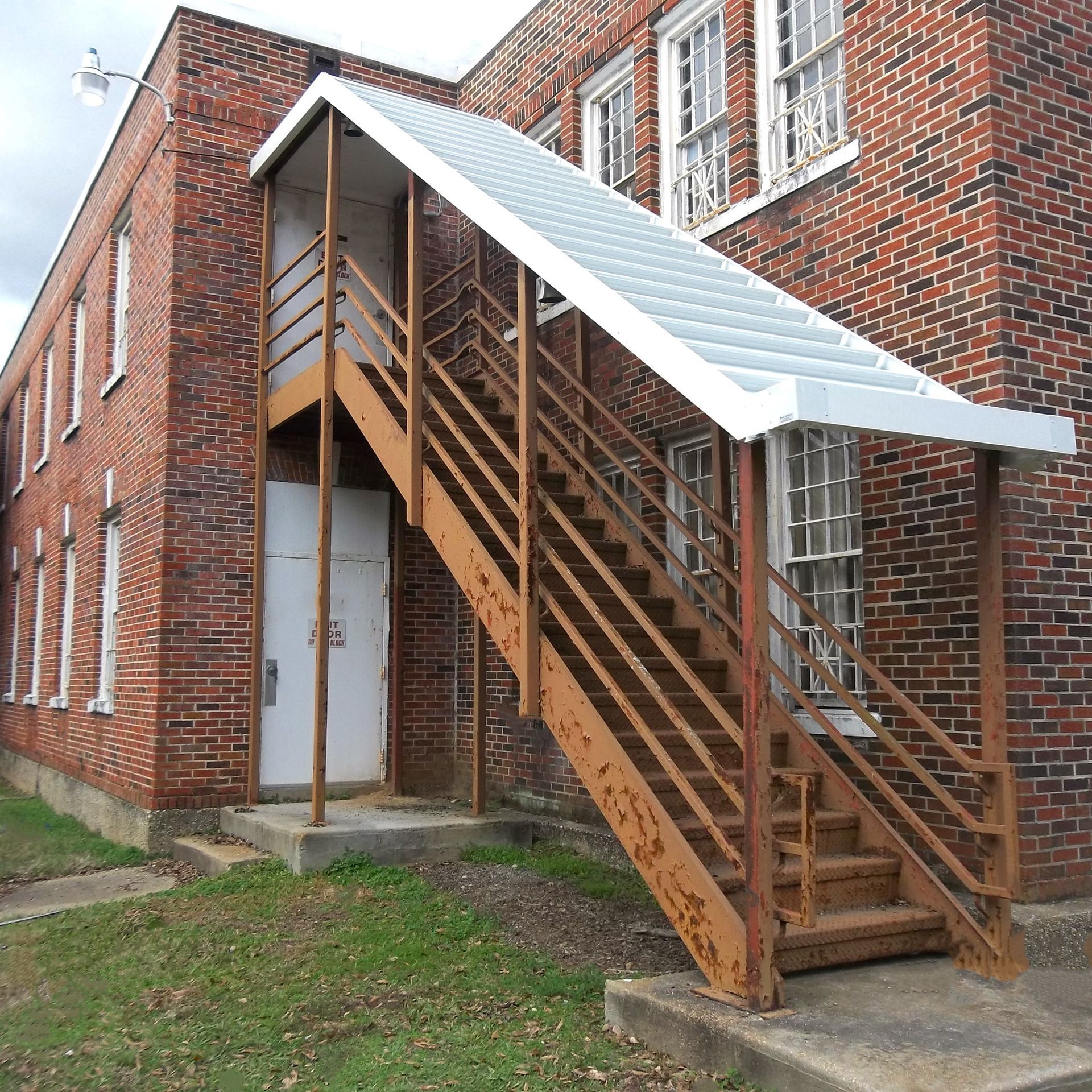 a brick building with stairs leading up to the second floor - Road Jackson, MS - French Awning & Screen Co.