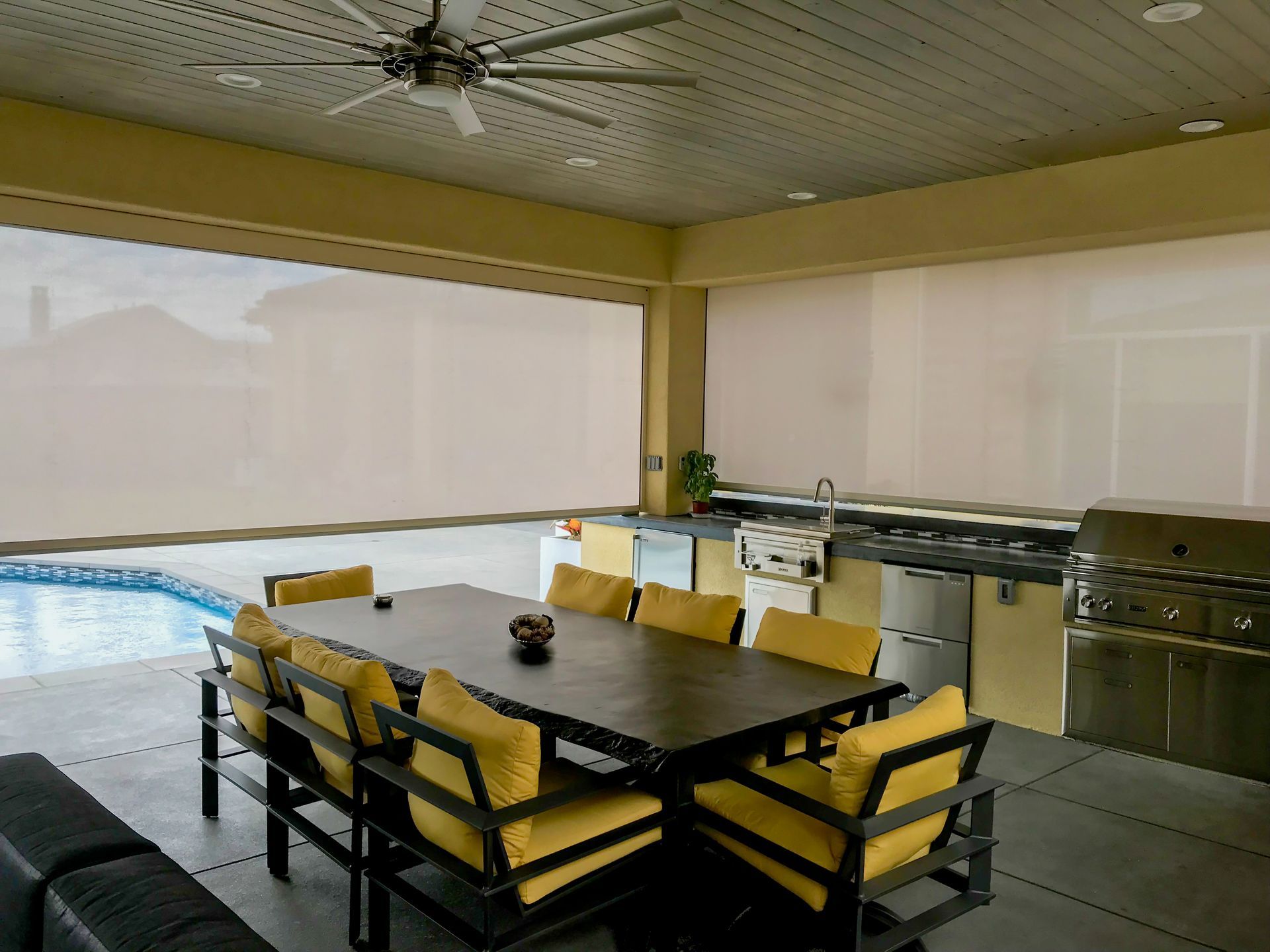 a patio with a table and chairs and a ceiling fan| Jackson, MS | French Awning an Screen Co