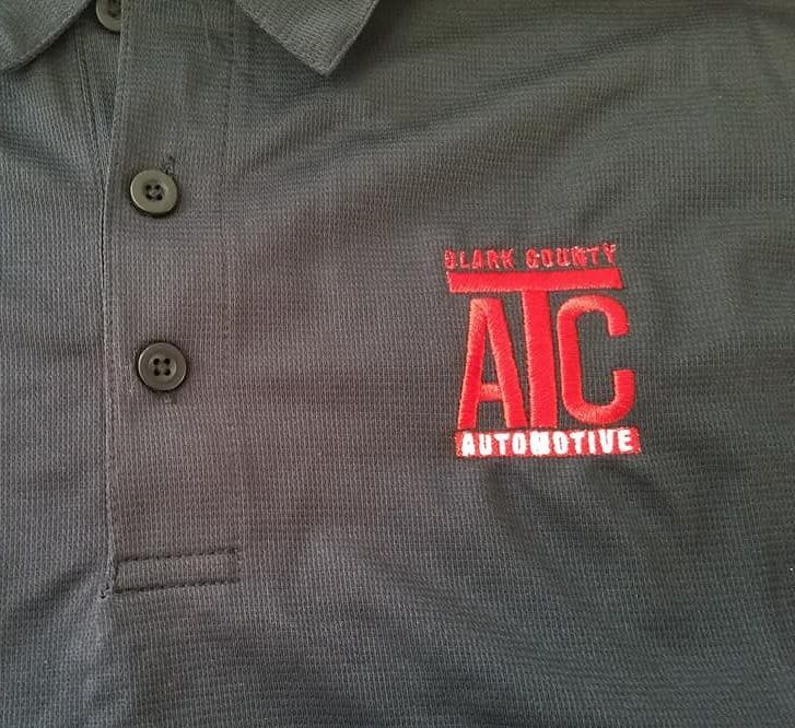 A black polo shirt with the word aic automotive embroidered on it